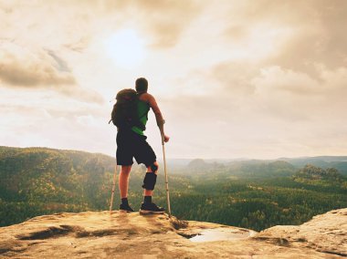Adam bir koltuk değneği ile ve kırık bacak koltuk değneği üzerinde sabit. Gezgin bandaj yaralı bacak ile kal devam et