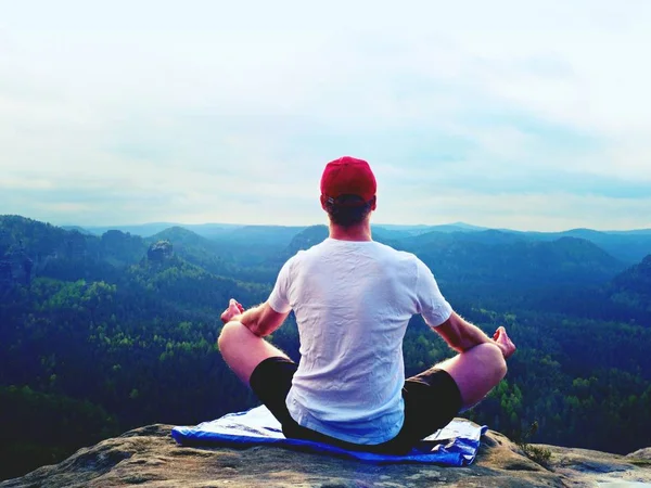 Yoga practicando en cumbre de montaña con vista aérea del valle de montaña. Deportista alto practicando yoga — Foto de Stock