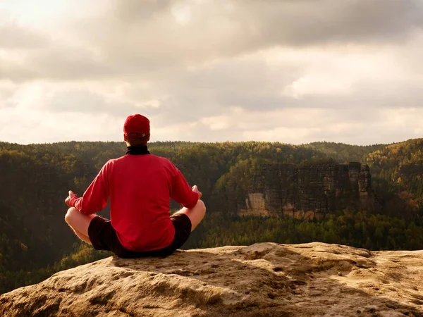 Hombre en la cima de la montaña en pose de yoga. Ejercicio yoga en el borde con una vista impresionante —  Fotos de Stock