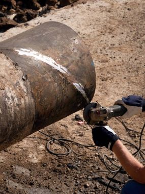 Adam çalışıyor, büyük boru spiral makinesi ile kesme. Kesilen yerden uzak uçan Hor sparks.