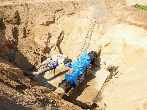 Grandes vannes industrielles dans les pipelines avec grand volant. Canalisation d'eau potable réparée dans un trou creusé . — Photo