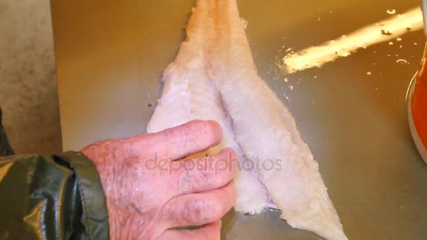 Checking the quality of the raw fish meat in the market with detail of butchers hand. Food industry, meat processing. Butcher checking parasite in raw meat of wild fish. — Stock Video