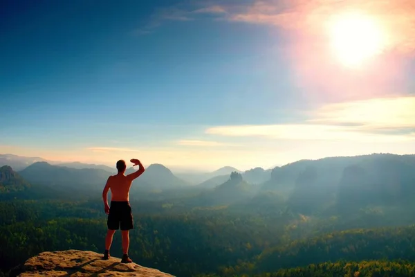 Nackter Mann in schwarzer Hose nur oben auf dem Berg bei Sonnenuntergang. — Stockfoto