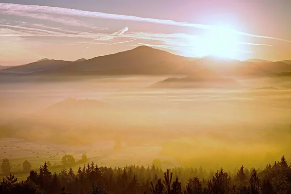 Sanfte neblige Landschaft in hügeligem Land. Der Herbst beginnt. Retro-Filter. Orangentonungseffekt. — Stockfoto