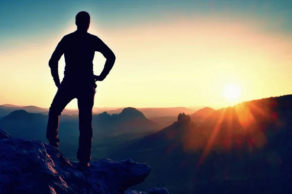 O homem está no pico da pedra de arenito no parque nacional Saxônia Suíça e olhando para o sol. Belo momento o milagre da natureza — Fotografia de Stock