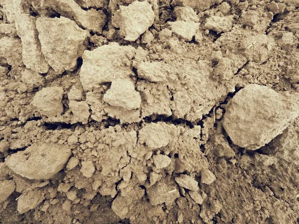 Kuiva pölyinen savi kentällä. Tyhjä kynnetty pelto odottaa kylvämistä. Kuuma kevätpäivä pellolla — kuvapankkivalokuva