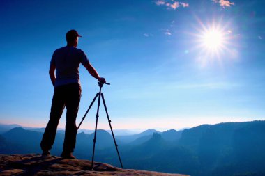 Tripod üzerinde cliff ve düşünme ile profesyonel fotoğrafçı kalırım. Rüya gibi adamlara manzara, mavi puslu gündoğumu bir güzel vadi