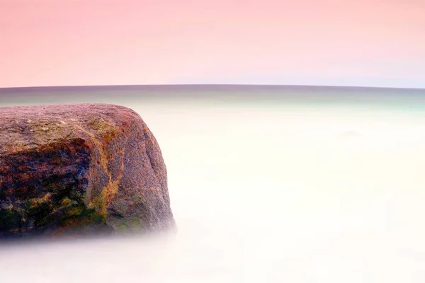 Romantische sfeer in rustige ochtend op zee. Grote keien van soepele golvende zee uitsteekt. Roze horizon — Stockfoto