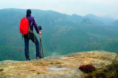 Uzun yürüyüşe çıkan kimse keskin kumtaşı kaya kaya empires park ve puslu ve sisli bahar vadi izlerken kırmızı sırt çantası ile
