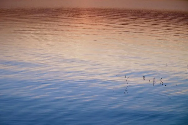 Hermoso amanecer de otoño o puesta de sol con Reflexión en el nivel del agua del lago. Ondas suaves . —  Fotos de Stock