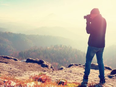 Cliff fotoğrafçı. Doğa fotoğrafçısı tepe üzerinde ayna kamera ile fotoğraf çeker