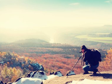 Cliff Professional'da. Doğa fotoğrafçısı karlı rock ayna kamera ile fotoğraf çeker.