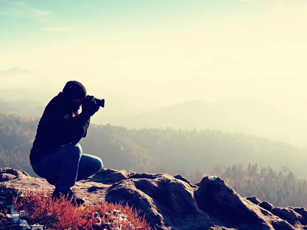 Diz aşağı fotoğrafçı kaya tepe üzerinde ayna kamera ile fotoğraf çeker
