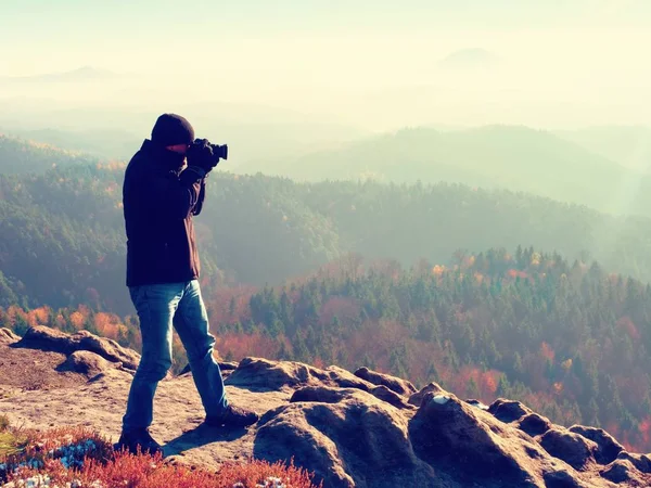 Photographe sur falaise. Photographe de nature prend des photos avec appareil photo miroir sur le pic — Photo