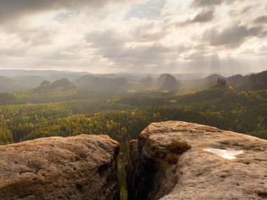 Kayalık tepe insanlar olmadan. Islak kumtaşı kayalık tepe üzerinde orman vadiye gizli güneş görüntüleyin.