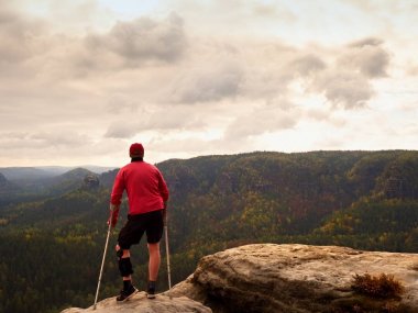 Ön kol koltuk değneği olan adam. Kırık bacak ile elde uzun yürüyüşe çıkan kimse dağ tepe hareketsiz