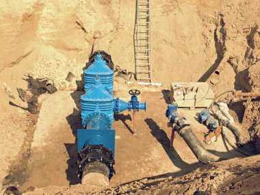 Büyük endüstriyel kapı vanalar büyük el çarkı ile boru hatları içinde. İçecek su boru hattı filmine delik tamir.