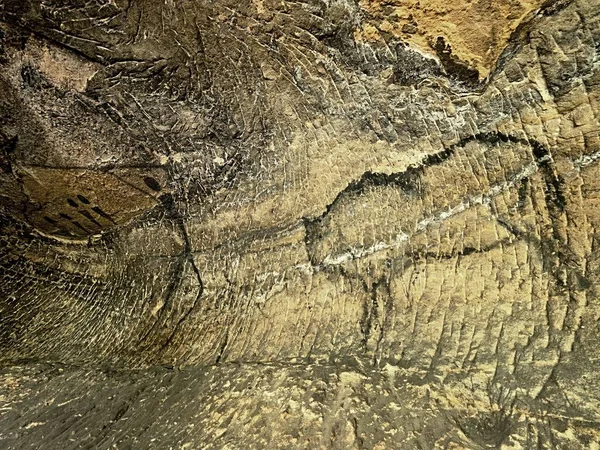 Måla av människans jakt på sandsten vägg, förhistoriska bilden. Svart abstrakt konst i sandsten grottan. — Stockfoto