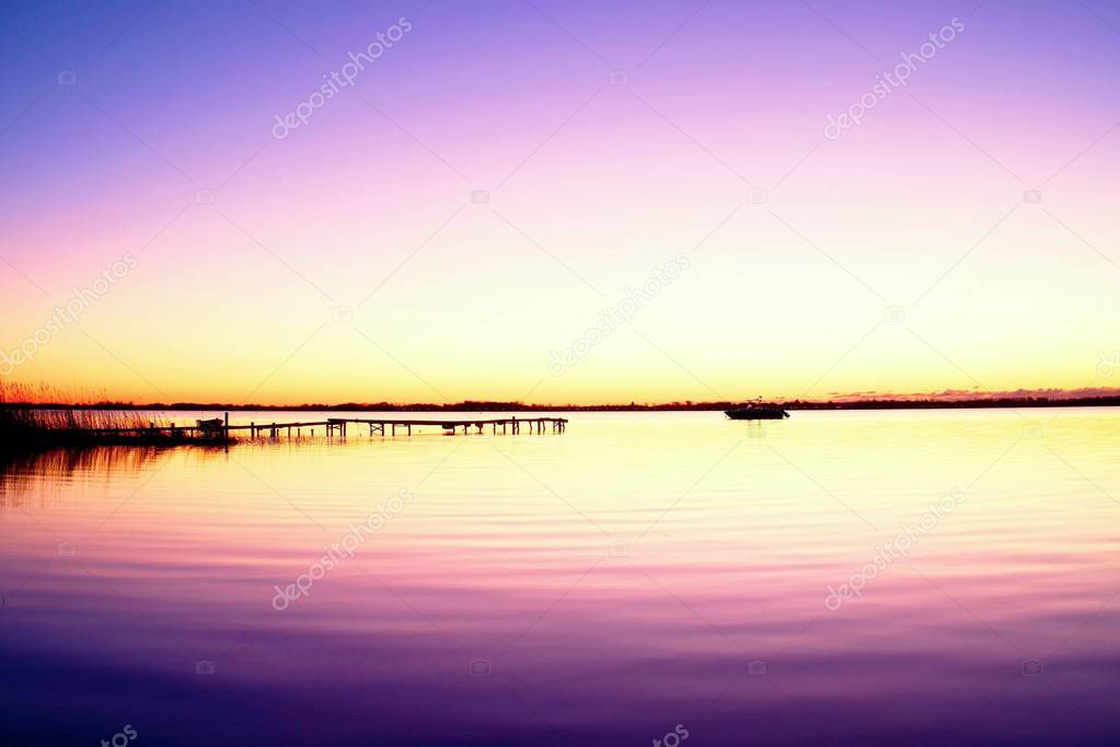 Morning in harbor. Tourists pier above sea. Sunny clear blue sky, smooth water level