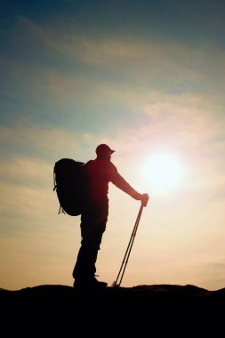 Windcheater turist ellerinde sportif trecking direkleri ile stand üzerinde kayalık bakış.