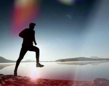 İnce genç fitness adam plaj, tropikal iz runner runner. Neşeli sporcu kumsalda koşmak