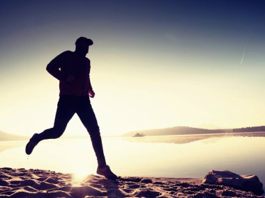 İnce genç fitness adam plaj, tropikal iz runner runner. Neşeli sporcu kumsalda koşmak