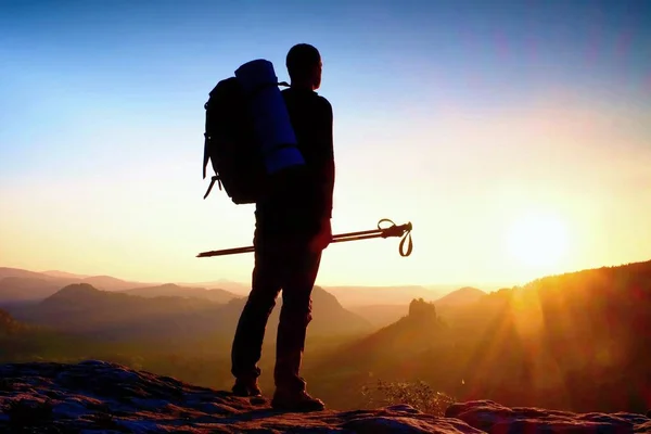 Silhouette affilata di un uomo alto sulla cima della montagna con sole nella cornice. Guida turistica in montagna — Foto Stock