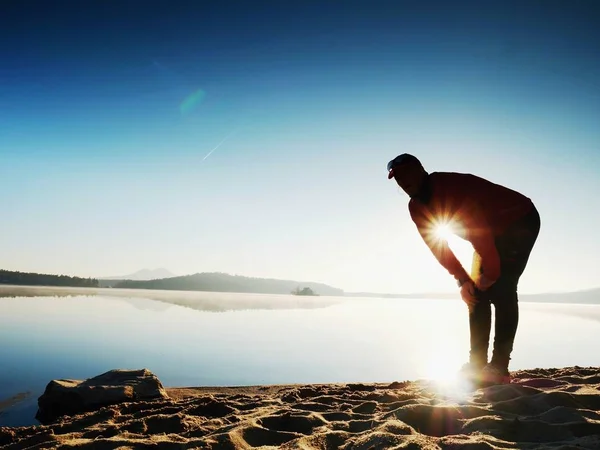 Sportsman s'étirant après le sport à la mer au lever du soleil le matin. Athlète se penchant en arrière — Photo