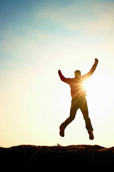 Стрибаюча людина. Молодий божевільний чоловік стрибає на барвистому фоні неба. Силует стрибаючого чоловіка та красиве небо заходу сонця . — стокове фото