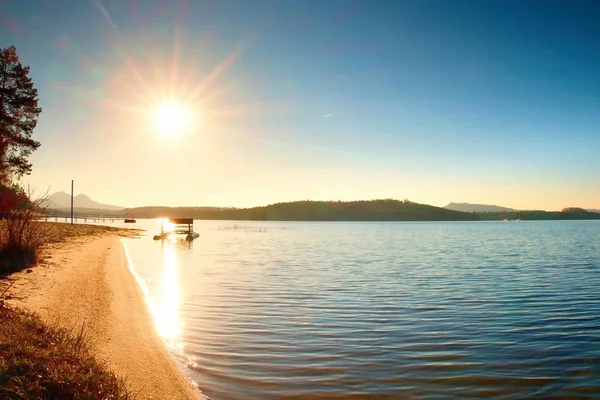 Övergiven gammal rostig paddel båt fastnat på sand på stranden. Vågigt vatten, ö vid horisonten. — Stockfoto