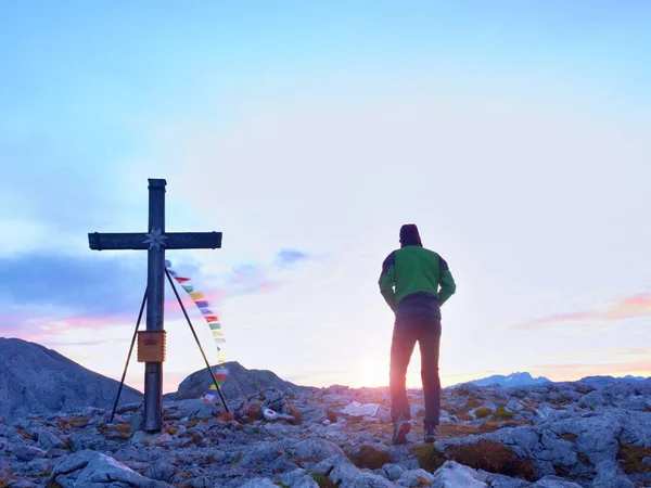 Tourist stand on rocky view point and watching into misty Alpine valley. Wooden cross — Stock Photo, Image