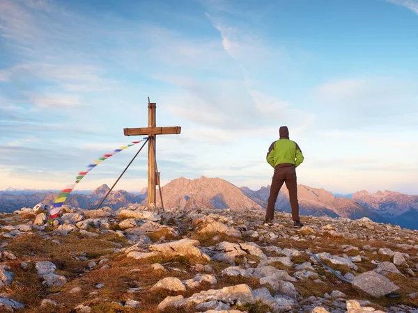 Man walk along the wooden cross at a mountain peak built to Alps victiims. Cross on top — Stock Photo, Image