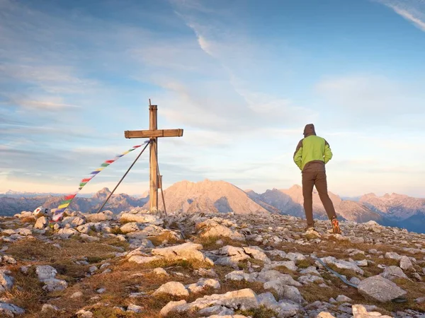 Alone man climber near the summit cross on peak, Dolomite Alps, Austria. Sunny windy evening. — Stock Photo, Image