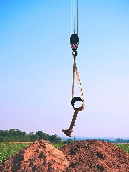 Hanging old tube on crane rope. Clear blue sky in background — Stock Photo, Image