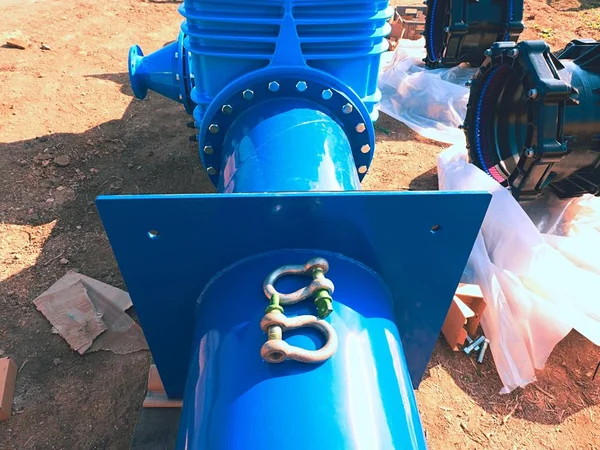 Big industrial gate valves in pipelines with big hand wheel. Repaired drink water pipeline in digged hole.