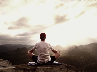 Dağ vadinin hava manzaralı dağ zirvesinde pratiği yoga. Uzun boylu sporcu pratik yoga