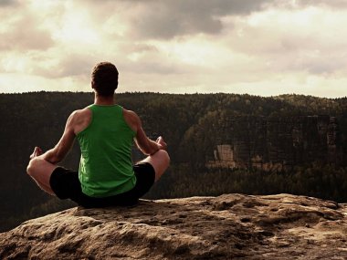 Adam yoga poz dağın zirvesinde. Egzersiz yoga nefes kesen manzarası ile kenarında