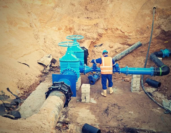 飲み物水システムの reconstrucion の地下労働者。ゲート弁で技術的な専門家 — ストック写真