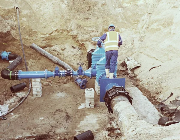 工人上闸板阀，重建的喝水系统地下 — 图库照片