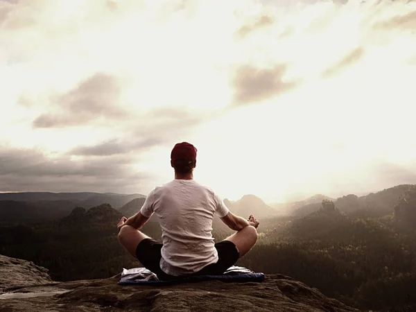 Yoga practicing  at mountain summit with aerial view of the mountain valley. Tall sportsman practicing yoga — Stock Photo, Image