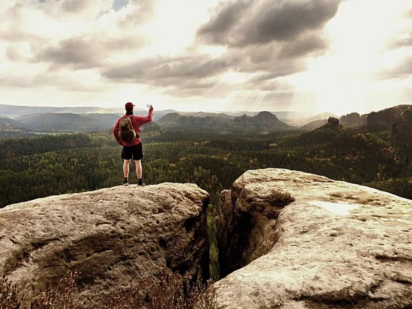 Fotógrafo de telemóvel. Turista na borda rochosa tirar fotos de telefone. Caminhadas nas montanhas — Fotografia de Stock