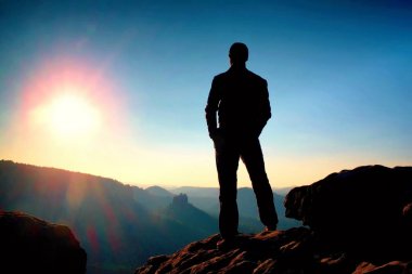 Keskin kayalık dağ zirvesine üzerinde ince turist Sun Vadisi'ne puslu ve sisli sabah üzerinde izliyor