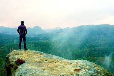 Uzun yürüyüşe çıkan kimse kumtaşı kaya kaya empires park ve puslu ve sisli bir bahar vadi izlerken keskin cliff üzerinde