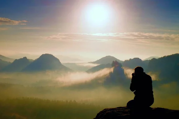 Photograph takes photos of daybreak above  heavy misty valley. Landscape view of misty autumn mountain hills and happy man silhouette — Stock Photo, Image