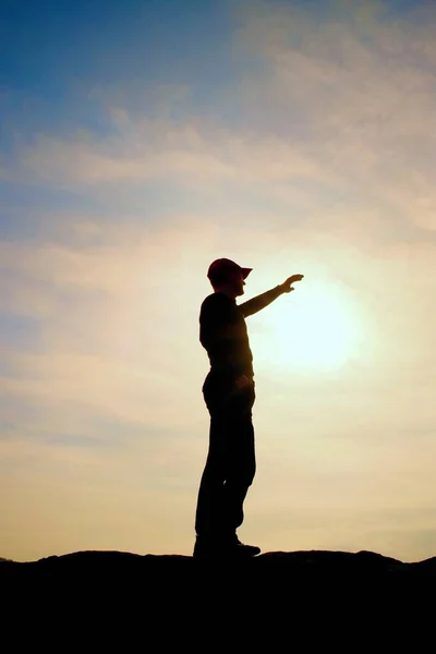 Turista en gorra de béisbol roja tocando a Sun. Caminante de pie en el pico de roca arenisca en el parque nacional — Foto de Stock