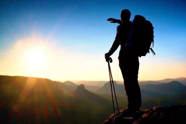 Silueta ascuțită a unui om înalt pe vârful muntelui cu soare în cadru. Ghid turistic în munți — Fotografie, imagine de stoc
