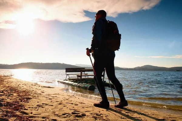 Turysta z plecak spacer w wodnym. Jesienny słoneczny dzień na plaży — Zdjęcie stockowe
