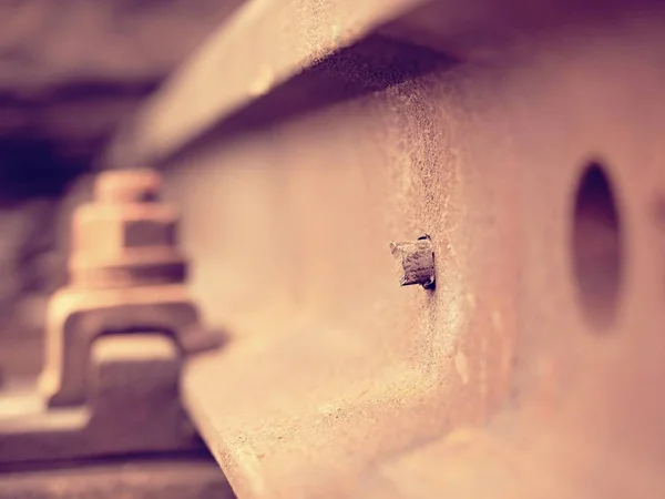 Selektive Schwerpunktsetzung. Detail rostiger Schrauben und Muttern auf alten Bahngleisen. Betonband — Stockfoto