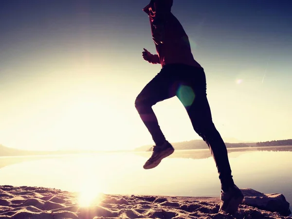 Silueta de atleta activo corriendo en la orilla del amanecer. Ejercicio de estilo de vida saludable —  Fotos de Stock