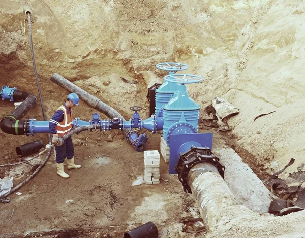 Worker underground for reconstrucion of drink water system. Technical expert at  gate valve — Stock Photo, Image